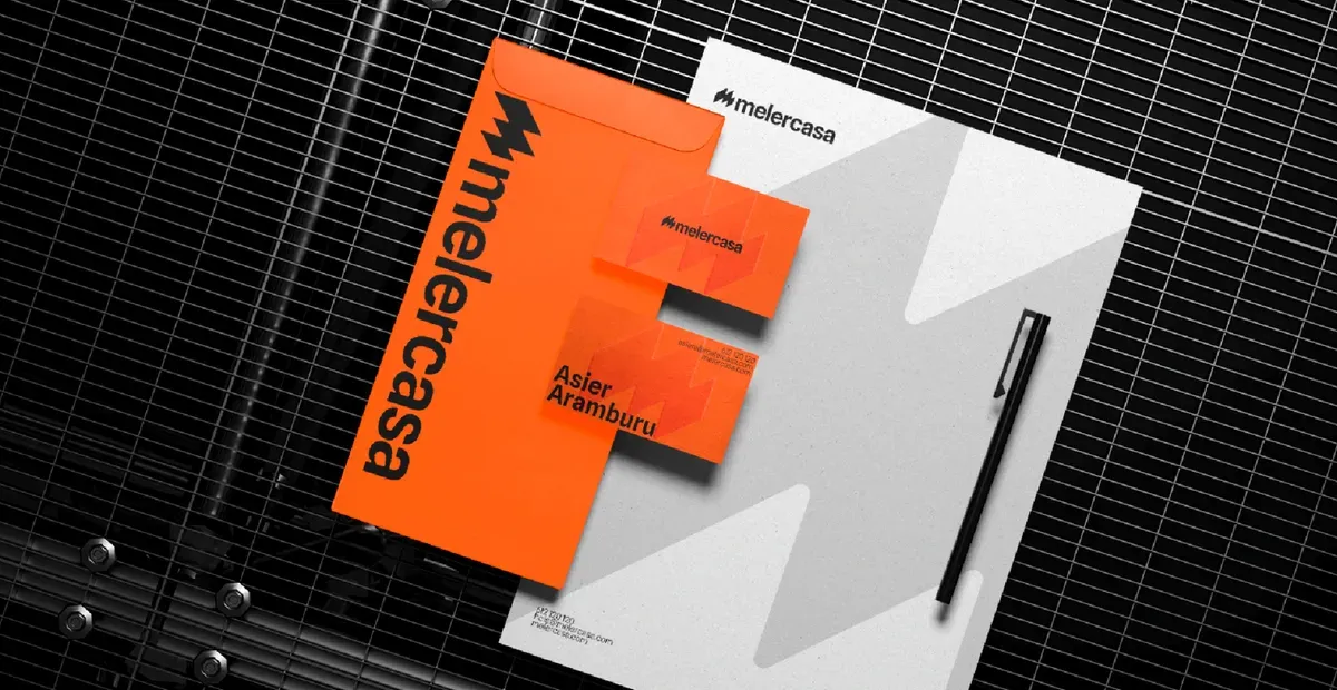 Papelería de Melercasa: sobre naranja, tarjetas de visita y hoja con el símbolo ampliado como marca de agua.