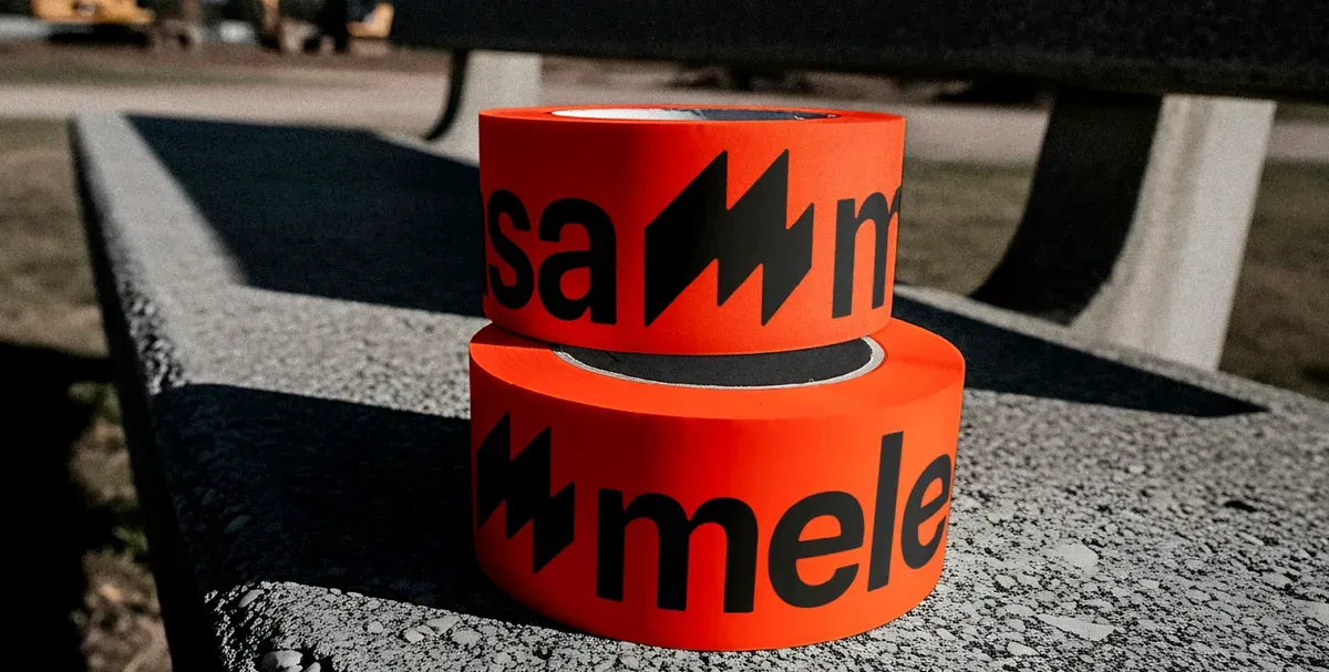 Dos rollos de precinto naranja con el símbolo y el nombre de Melercasa en negro.